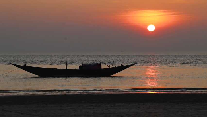 Sunset and a boat A view of the mangrove forest beach of Dublar Char in the Sundarbans.