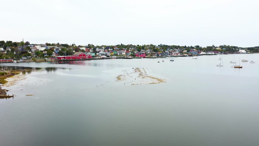 Aerial drone footage of the town of Lunenburg which is a historic port town in Nova Scotia Canada showing the historical colourful buildings by the ocean front in the fall autumn time