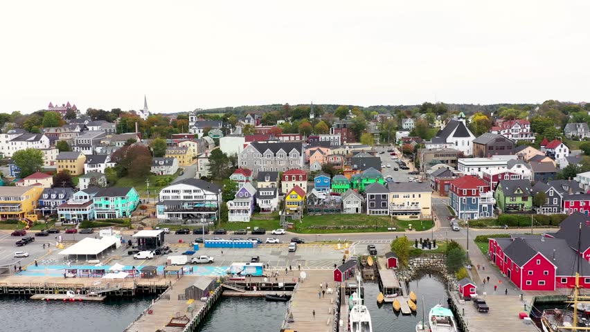 Aerial drone footage of the town of Lunenburg which is a historic port town in Nova Scotia Canada showing the historical colourful buildings by the ocean front in the fall autumn time