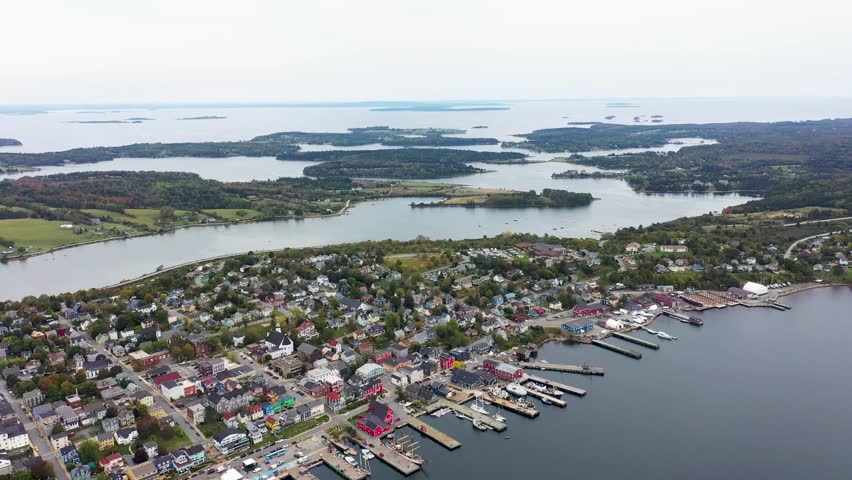 Aerial drone footage of the town of Lunenburg which is a historic port town in Nova Scotia Canada showing the historical colourful buildings by the ocean front in the fall autumn time