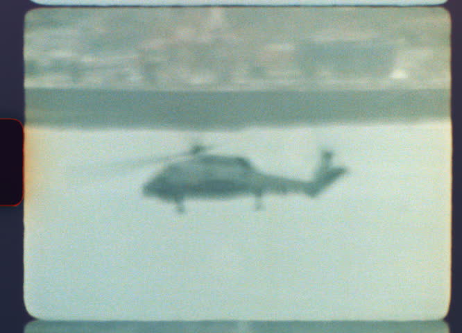 Authentic Super 8mm film captures a military helicopter flying low over the sea during a patrol mission, showcasing a genuine retro aesthetic with grain, scratches, and light leaks