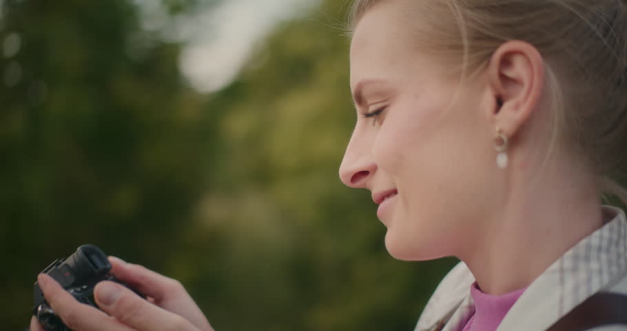 Close-up of a photographer putting camera to eye during outdoor photoshoot, capturing the moment.
