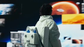 Cheerful astronaut dancing while monitoring mission data on displays. Jolly spacecraft cosmonaut having fun doing dance moves while looking at space travel multimedia digital backdrop, camera B - Powered by Shutterstock - Get 15% off with code: PIKWIZARD15