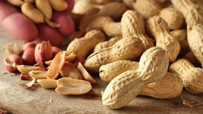 Peanut butter ingredient.Peanuts. Groundnuts.fingers peeling peanut kernels from their shells. 4k footage