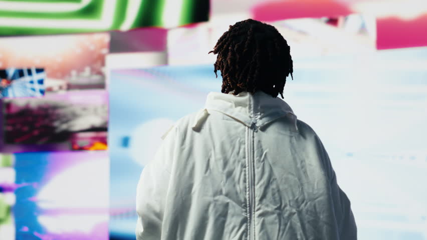 Happy astronaut in futuristic space suit doing dance moves against vibrant cosmic visuals backdrop. Playful african american woman dancing, having fun during space exploration, camera B - Powered by Shutterstock - Get 15% off with code: PIKWIZARD15