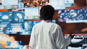 Smiling healthcare researcher mesmerized by futuristic medical data visualizations, working on disease prevention research. Scientist awed by high tech patient scans on digital interface, camera B - Powered by Shutterstock - Get 15% off with code: PIKWIZARD15