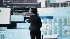 Manager speaking at professional fintech convention, showing business market graphs to shareholders. Businesswoman presenting financial reports and data charts infographics on digital screen, camera A - Powered by Shutterstock - Get 15% off with code: PIKWIZARD15