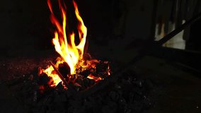 Glowing charcoal pieces igniting flames, metal rod plunging into fire to heat tip, embers drifting. Industrial, craftsmanship, heat, metallurgy, artisanal, rustic, fiery - Powered by Shutterstock - Get 15% off with code: PIKWIZARD15