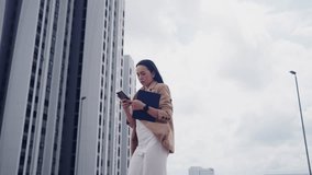 Confident Asian businesswoman walking in city holding smartphone and tablet. Urban professional female executive leader outdoors. - Powered by Shutterstock - Get 15% off with code: PIKWIZARD15