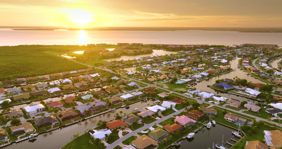Punta Gorda, Florida at evening hour. Waterfront suburban houses and palm trees shine in warm tropical sunset atmosphere.