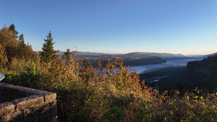 4K footage of sunrise view from Portland Women’s Forum State Scenic Viewpoint overlooking Vista House and Columbia River Gorge, Oregon, USA. Morning light, fall trees, and peaceful autumn landscape