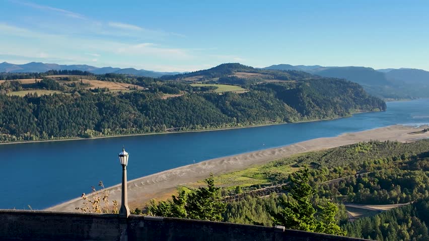 4K footage of early morning view from Vista House at Crown Point overlooking Columbia River Gorge, Oregon, USA. Scenic valley, calm river, autumn air, and clear blue sky in peaceful nature fall scene