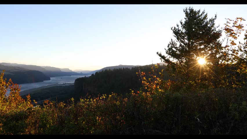 4K footage of sunrise view from Portland Women’s Forum State Scenic Viewpoint overlooking Vista House and Columbia River Gorge, Oregon, USA. Morning light, fall trees, and peaceful autumn landscape