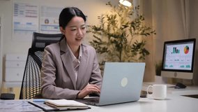 Businesswoman working on a laptop in a modern office, analyzing data and reports with focus and professionalism. - Powered by Shutterstock - Get 15% off with code: PIKWIZARD15