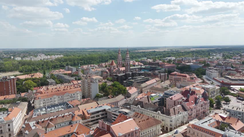 Aerial view of Szeged’s cityscape with the Votive Church visible in the distance, highlighting rooftops, streets, and historic architecture.