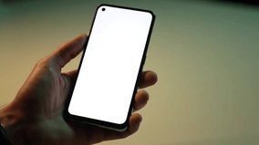 Person holding a smartphone with blank white screen on neutral background - Powered by Shutterstock - Get 15% off with code: PIKWIZARD15