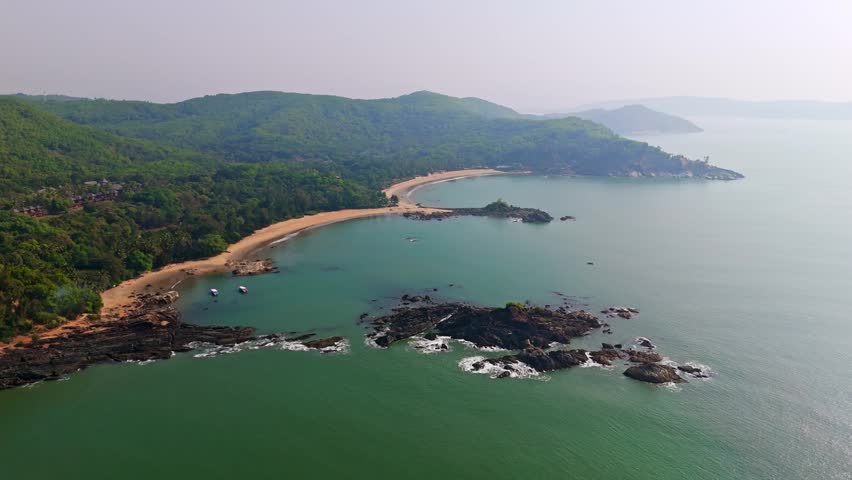 Aerial view backwards in front of the Om beach, hazy sunrise in Gokarna, India