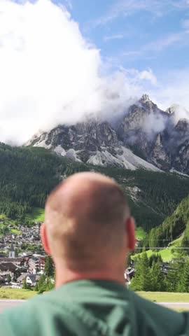 Man looking at alpine mountain landscape in Dolomites, Italy