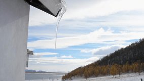 An icicle hangs from the roof of a rustic log cabin in a remote Mongolian forest. A peaceful scene of winter solitude and life in a cold, natural environment. - Powered by Shutterstock - Get 15% off with code: PIKWIZARD15