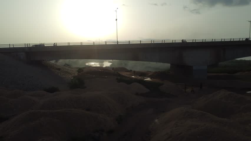 Aerial view of the expansive Benue River under a bright sun, with a bridge stretching across its waters, creating a striking contrast, Makurdi, Benue, Nigeria.