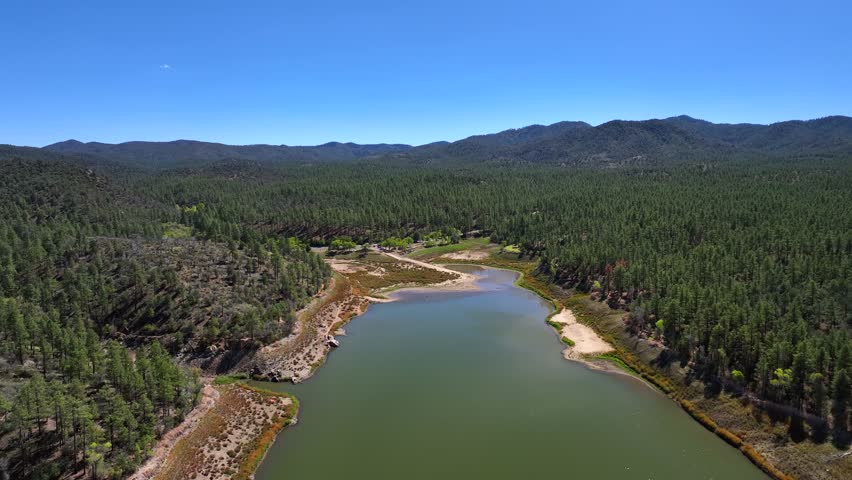 Aerial view of Lynx Lake surrounded by dense forests and mountains, the water reflecting the sky, a tranquil scene, Lynx lake, Prescott, Arizona, United States.