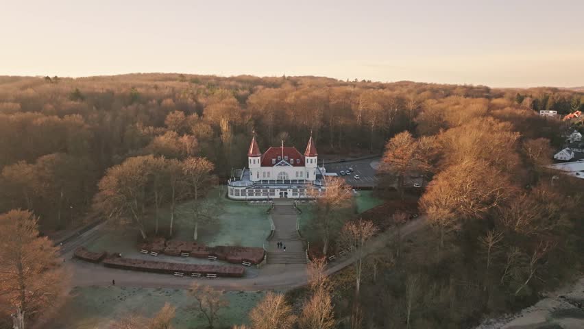 Drone footage of Varna Mansion and Marselisborg Forest in late autumn near Aarhus, Denmark. Bare trees and soft coastal light capture a quiet Nordic atmosphere.