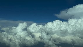A pilot’s POV in a flight near massive storm clouds ahead at nightfall, with a dark blue sky and towering cumulonimbus evolving bellow. - Powered by Shutterstock - Get 15% off with code: PIKWIZARD15