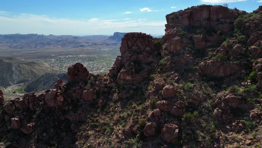 Aerial view of Globe, Arizona, a city nestled among rugged mountains, showcasing winding roads and a desert landscape under a vast blue sky, Globe, Arizona, United States.