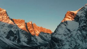 This drone footage shows beauty of the Troll Wall Trollveggen in Norway, captured during the golden hour as the setting sun casts a warm alpenglow across its snow-capped peaks. - Powered by Shutterstock - Get 15% off with code: PIKWIZARD15