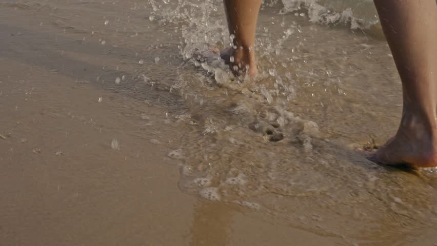A back view of a young womam in bikini walking on the beach. A sense of adventure, freedom, and travel during a summer vacation