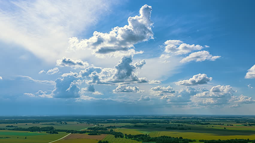 Clouds moving in a time lapse over green plain
