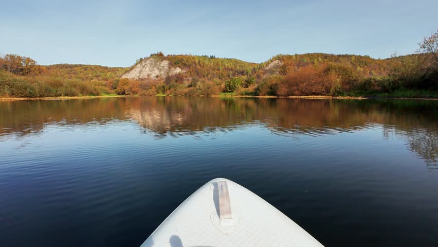 Immerse yourself in a truly serene kayaking adventure as you glide through the stunningly vibrant autumn colors, all while enjoying the peaceful moments of reflection on the calm lake waters