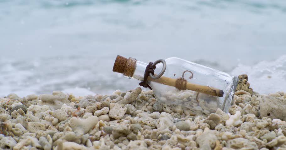 Message in the bottle on a sand beach. Shot on super slow motion camera 1000 fps.