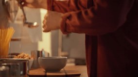 In a warm kitchen, a man serves a bowl of creamy pumpkin soup with fresh pumpkin, preparing a delicious autumn dinner. Soft lighting creates a cozy atmosphere as evening approaches - Powered by Shutterstock - Get 15% off with code: PIKWIZARD15