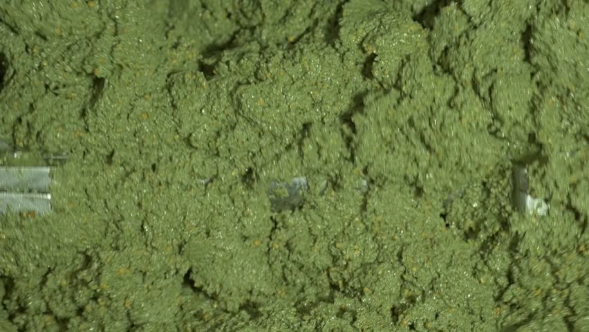 Freshly ground green olive paste (pulp or mass) being stirred in the blender. This is the key step in the olive mill before the extraction of Extra Virgin Olive Oil.