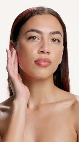 Woman, touch face and beauty in studio with results, texture and smooth skin on white background. Person, model and portrait with cosmetics, natural makeup and glow with transformation in Colombia