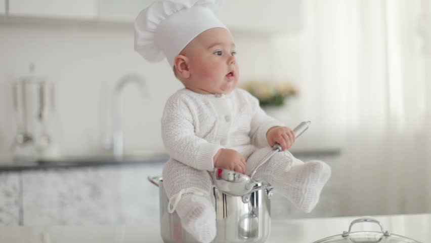 Little cook with a ladle near the pan
