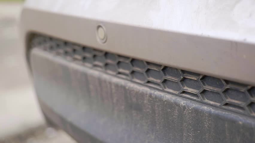 Super dirty and muddy rear bumper trime on SUV with hexagon pattern