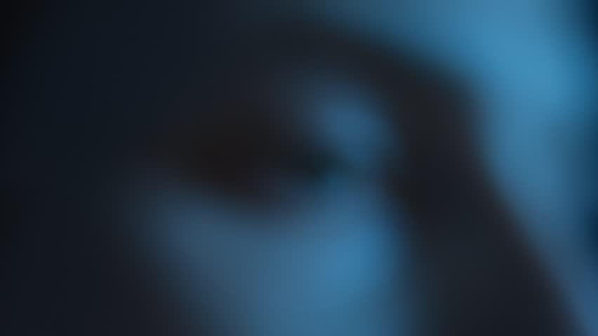 Zoom in close up of wide open human eye looking at glowing display with smartphone screen reflection on pupil illuminated by blue light. Social media addiction, doomscrolling, or insomnia concept