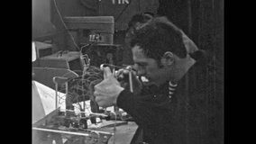 Technician man solders components on electronic circuit board technology at factory equipment. Manufacturing, engineering in industrial production. Old film. Archival retro 1960s. Vintage archive - Powered by Shutterstock - Get 15% off with code: PIKWIZARD15