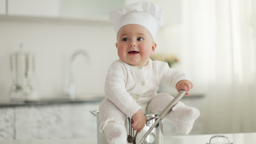 Little chef sitting in pot with ladle in hand
