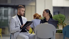 Business people engage in a productive discussion, working together in a modern, dynamic environment. The man takes notes while the woman uses a laptop, showcasing collaboration and focused effort. - Powered by Shutterstock - Get 15% off with code: PIKWIZARD15