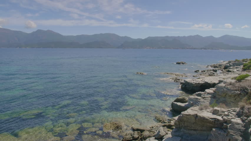 Saint-Florent Corsica coast sunny view of crystal clear turquoise waters rocky shorelines under a bright blue sky untouched natural beauty serene Mediterranean landscape northern Corsican seaside