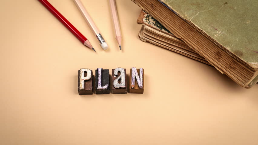 Stop motion scene showing letter N changing to letter Y forming the word play with vintage wooden letters and old books  