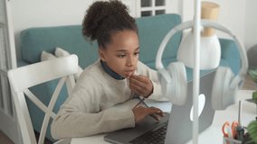 Primary middle school African American Student child girl study use laptop. Distance learning online education. School girl type at home with digital tablet computer and doing school homework. - Powered by Shutterstock - Get 15% off with code: PIKWIZARD15