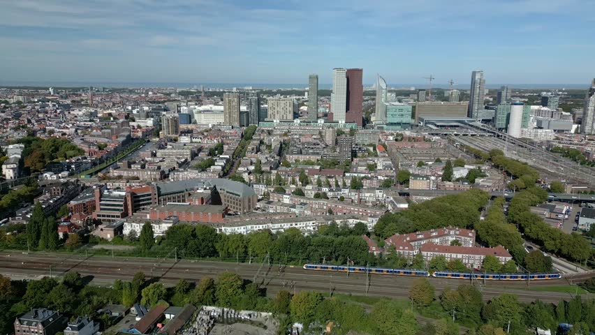 An aerial view of The Dutch Hague city with high-rise buildings and multiple train railways intersecting at the daytime in Netherlands