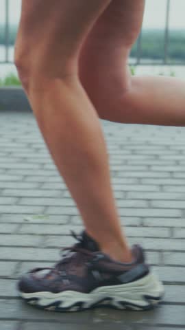 Dynamic Running Footage Focused on Athletic Footwear in Motion Capturing the Essence of Sport and Movement on a Paved Surface Outdoors