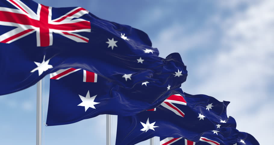 Australia national flags waving in the wind on a clear day. Blue flag with Union Jack, white 5-pointed star symbolizing Southern Cross. Seamless 3d render animation. Slow motion loop. Selective focus