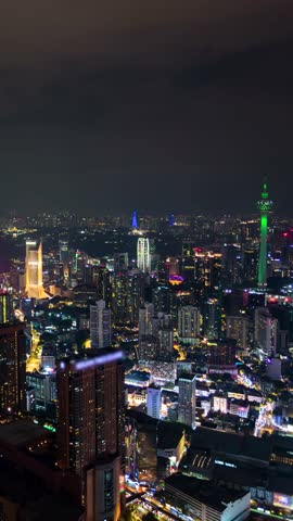 Aerial night timelapse of Kuala Lumpur city with illuminated skyscrapers, glowing skyline, and modern urban lights showcasing the vibrant atmosphere of Malaysia