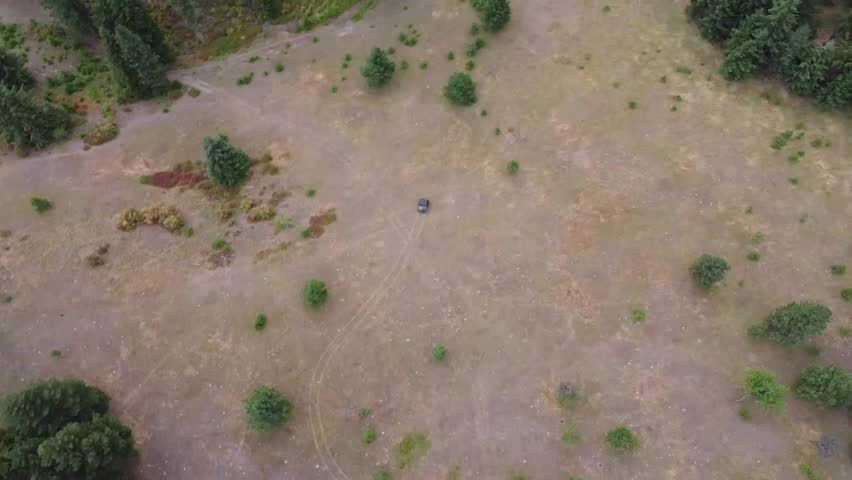 Aerial drone video of a 4-wheeler riding through pine woods on rugged trails outside Colville, Washington, with views of the Northeast Cascades and Stevens County terrain.
